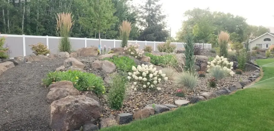 Rock garden berm with boulders and ornamental grasses